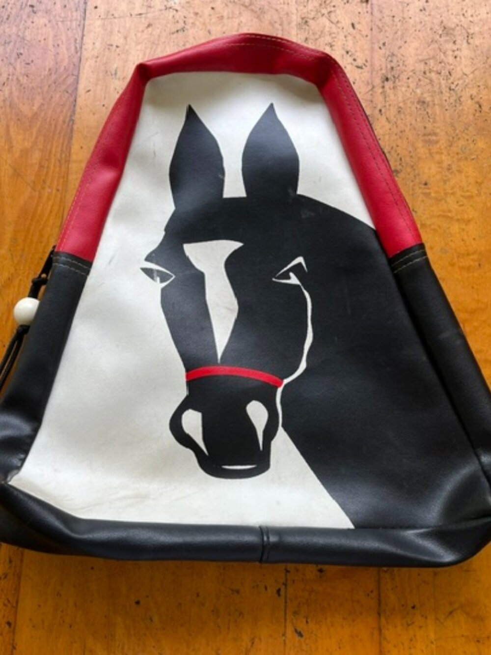 Horse head sling back backpack, red, white, and black.